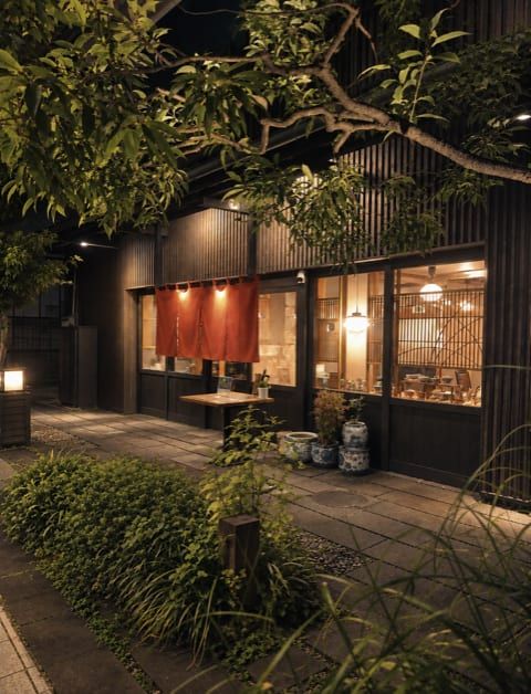 夜裡，紅色暖簾與格子窗透出燈光的「れんげ草」外觀