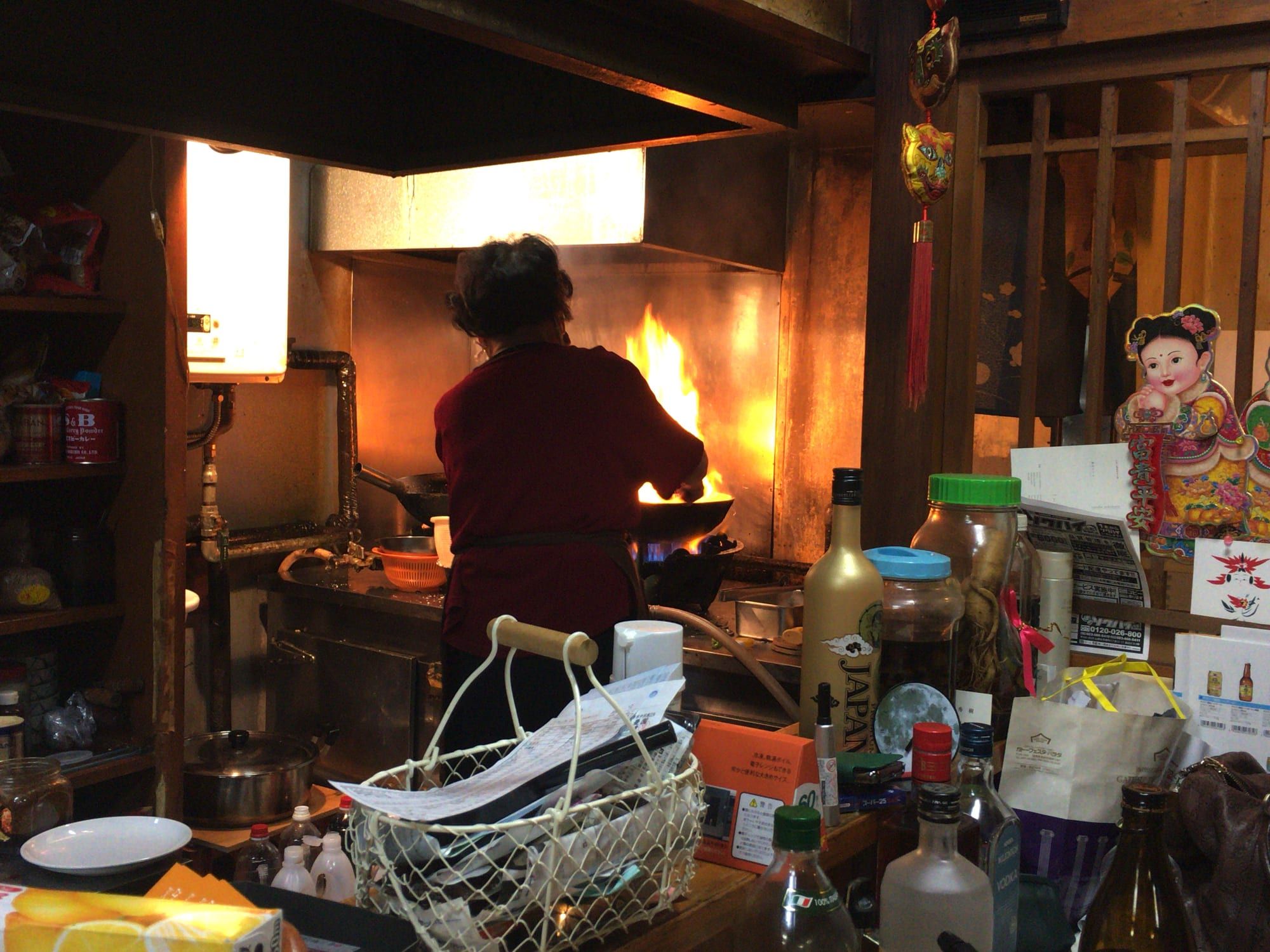 中華鍋に炎を上げながら調理するママ